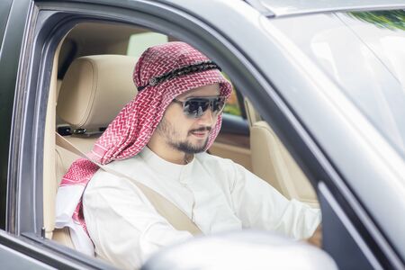 Picture of Arabian businessman driving a new car while wearing sunglassesの写真素材