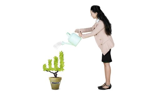 Caucasian businesswoman watering a plant in the pot with profit word, isolated on white backgroundの写真素材