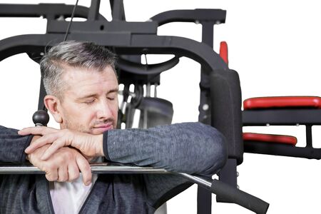 Close up of Caucasian man sleeping on the exercise machine while exercising in the studio