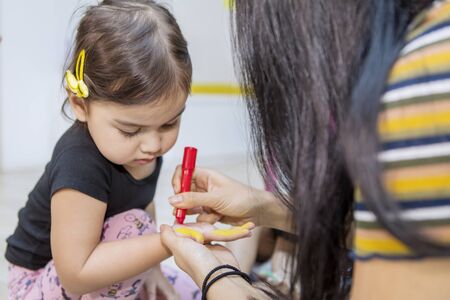 Cute little girl hands colored by her teacher while playing in the kindergartenの写真素材