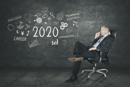 Picture of caucasian businessman sitting on a chair and thinking to make strategy, shot with scribble backgroundの写真素材