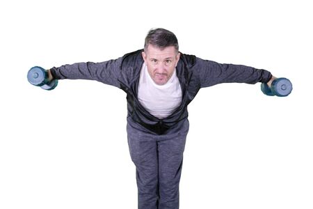 Caucasian man doing exercises with two dumbbells while standing in the studio, isolated on white backgroundの写真素材