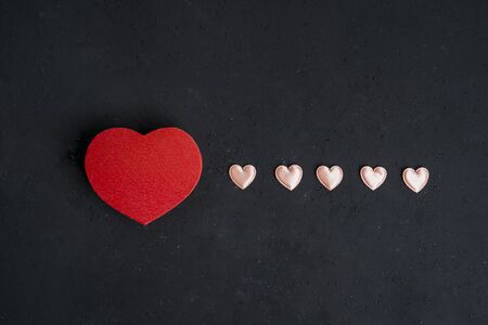 Flat layout of valentine box and love knick knacks in a straight line, isolated in black wall backgroundの写真素材