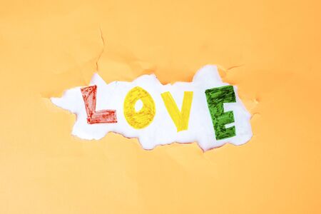 Love stickers text on the crack of the wall, with orange backdropの写真素材