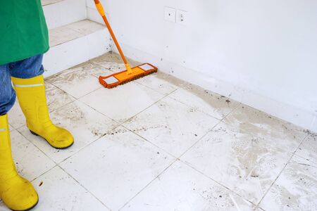 Professional worker cleaning dirty floor using a mop