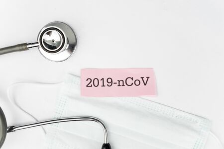 Flat layout of pink 2019 nCoV label with stethoscope and transparent face mask surrounding, isolated...