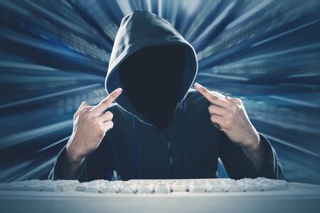 Portrait of shadowy figure wearing hoodie while showing middle finger to camera, isolated in binary...