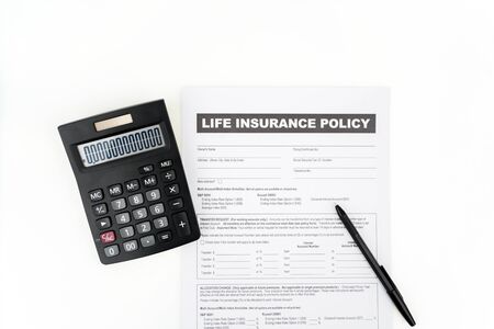 Top down view of life insurance policy document near a calculator and a pen, isolated in white backgroundの写真素材