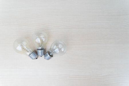 Flat lay of three light bulb on wooden table with copy space