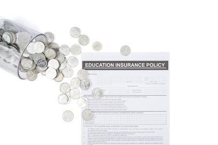 Flat layout of education insurance policy document paper near scattered coins, isolated in white backgroundの写真素材