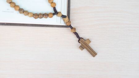 Flat lay of wooden cross and bible on the table