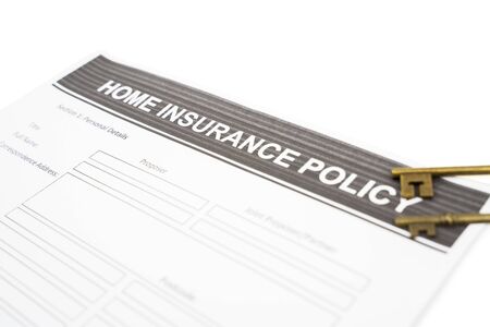 Closeup of home insurance policy document paper near some old keys, isolated in white backgroundの写真素材