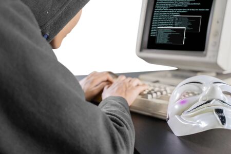 Picture of unknown man stealing information from system with clown mask on the table, isolated on...