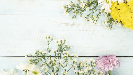 Flat lay of flowers frame on blue wooden background with copy spaceの写真素材