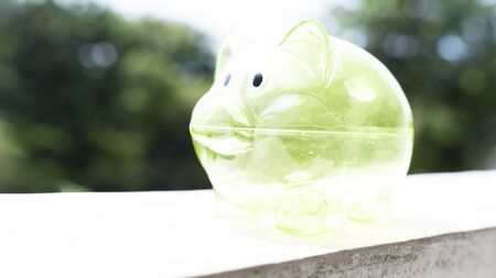 Closeup of green empty transparent piggy bank on the windowの写真素材