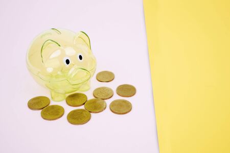 Piggy bank with golden coins and copy space in the studio. Savings money conceptの写真素材