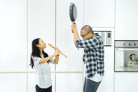 Little girl playing a spatula as a flute to her father like swayed snake while having fun in the...