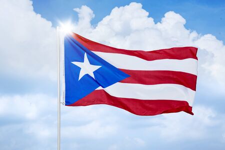 Cuba country flag blowing in the wind on flagpole under blue sky. Shot at outdoorsの写真素材