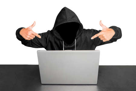 Hacker pointing at the laptop computer on the table with two hands, isolated on white background