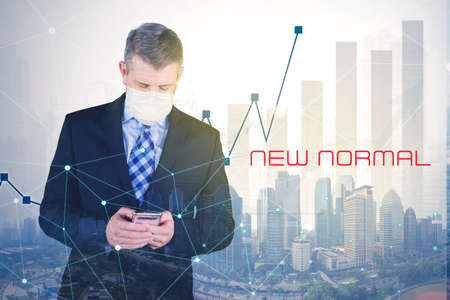 Confident businessman wearing face mask while standing near growth business chart with coronavirus backgroundの写真素材