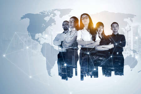 Double exposure of confident multiracial business team standing with network connection and world map backgroundの写真素材