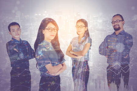 Double exposure of multiracial business people folded hands and standing with night city background