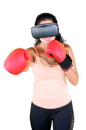 Curly hair woman wearing VR glasses while boxing workout in the studio. Isolated on white backgroundの写真素材