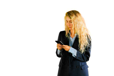 Blonde businesswoman using a mobile phone while standing in the studio. Isolated on white background