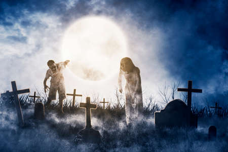 Two horrible ghosts walking in the graveyard after rising out of the ground with moon background....