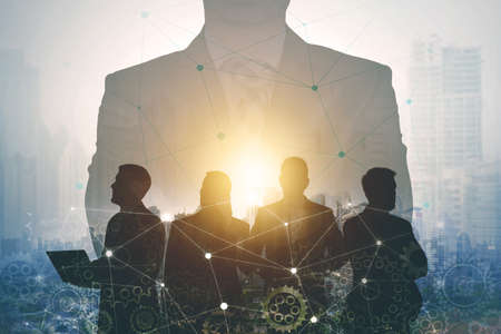 Double exposure of a confident business leader with his partners working together on modern city backgroundの写真素材
