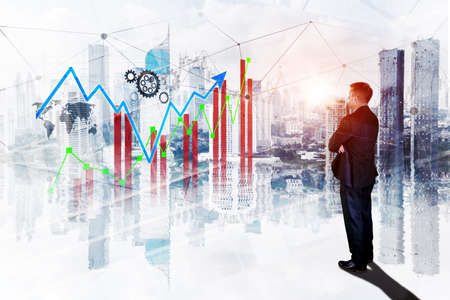 Rear view of male manager looking at growth finance graph with double exposure of modern city...
