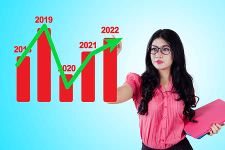 Young businesswoman drawing a future growth business chart plan for the new year 2021 on the whiteboard in the officeの写真素材