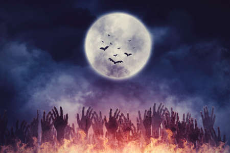 Halloween horror concept. Crowded ghost hands rising from hell in dark Halloween night with moon backgroundの写真素材