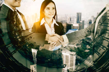 Three business people shaking hands to sign agreement with double exposure of industrial port...