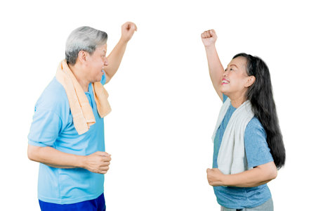 Side view of happy old couple wearing sportswear while exercising together in the studio. Isolated on white backgroundの写真素材