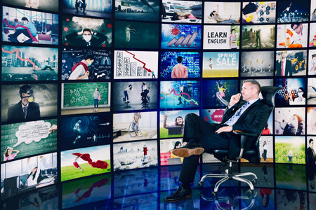 Pensive businessman looking at pictures on virtual screen for project while sitting on the chair