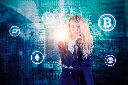 Caucasian businesswoman looks pensive while standing with bitcoin symbols in circuit board background. Shot at cyberspaceの写真素材
