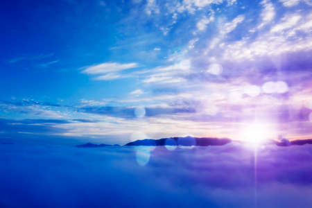 Aerial scenery of misty morning above mountain with blurred sparkling lights backgroundの写真素材