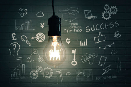 Close up of a bright light bulb with doodles on bricks wall backgroundの写真素材