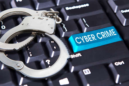 Close up of handcuff with cybercrime text on the keyboard buttonの写真素材