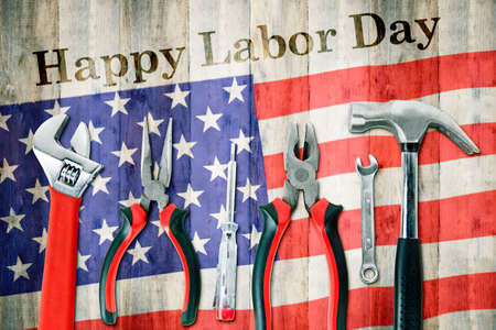 Labor day concept. Top view of handy tools with Happy Labor Day text on American flag table backgroundの写真素材