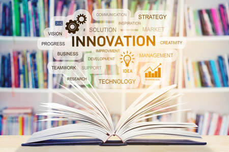 Close up of open book with innovation word cloud in bookcase background. Shot in the libraryの写真素材