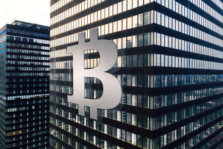 Aerial view of office building windows reflecting skyscrapers with Bitcoin symbol