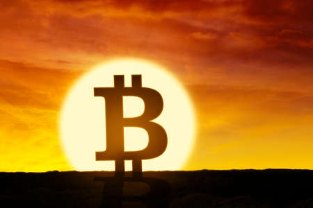 Silhouette of Bitcoin symbol with orange sky background at sunset timeの写真素材