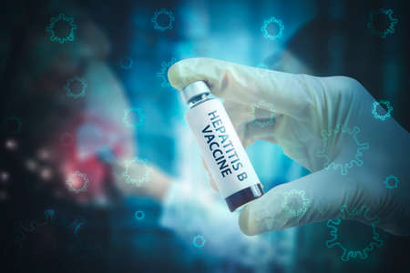 Close up of doctor hands holding a Hepatitis B vaccine bottle with Hepatitis virus backgroundの写真素材