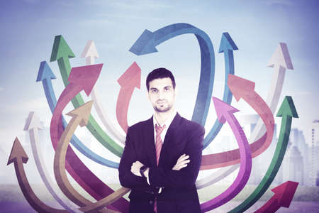 Confident businessman wearing formal suit while standing with colorful upward arrows in cityscape...