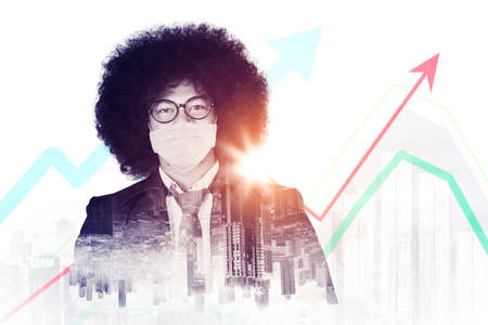 Double exposure of afro businessman wearing face mask while standing with upward arrow and modern...