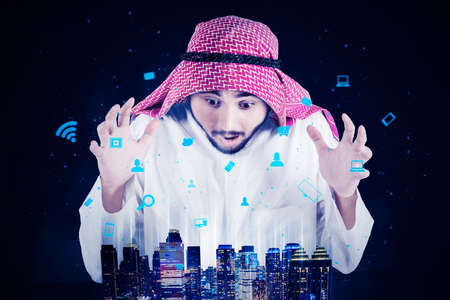 Arabian man looks amazed while looking at the smart city in cyberspace