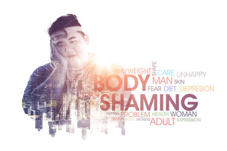 Double exposure of fat man looks depressed while thinks his body problems and standing with body shaming textの写真素材