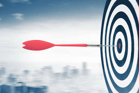 Image of red dart moving toward the target with speed motion in misty city backgroundの写真素材